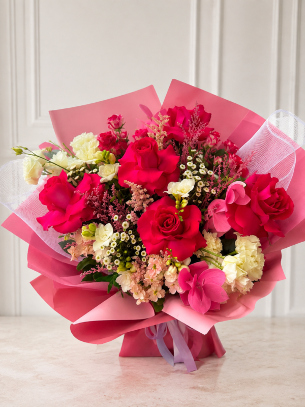 Buchet romantic cu trandafiri roșii și flori în nuanțe de roz